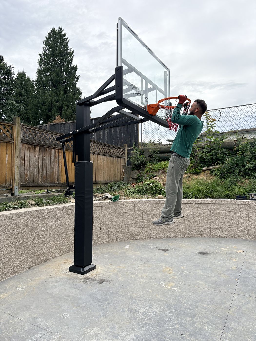 Side profile of the basketball hoop showing backboard, rim, arm, and post