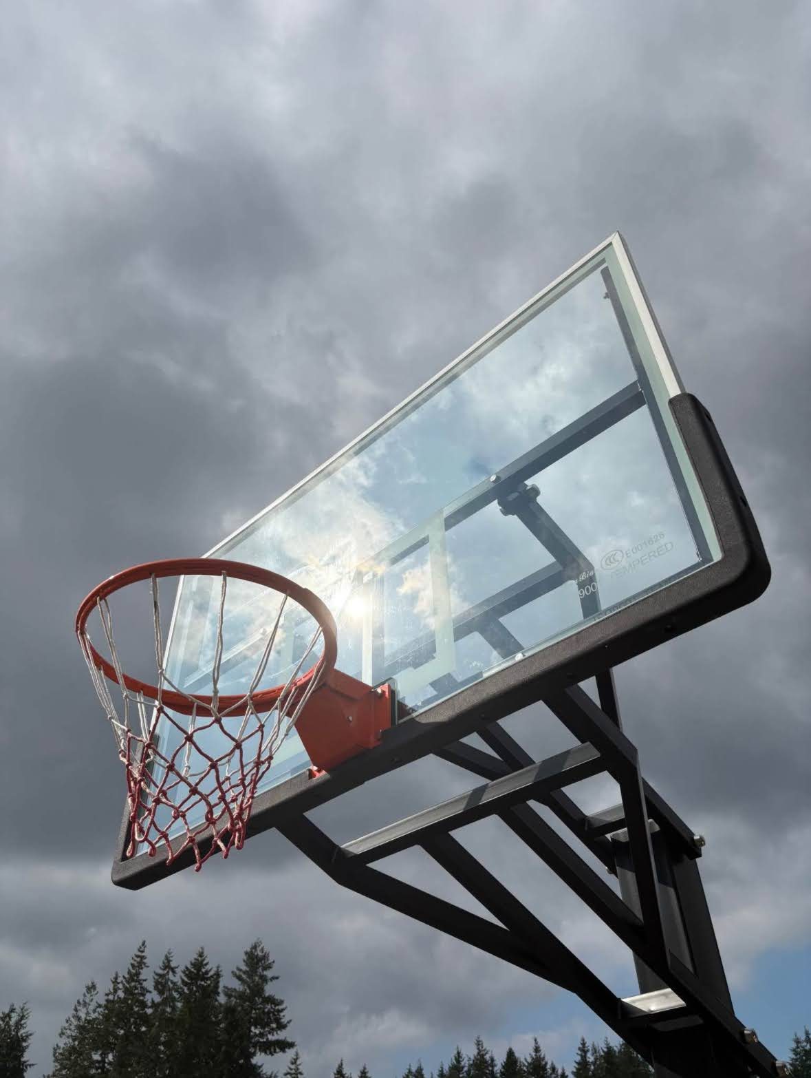 Heavy-duty basketball hoop tempered glass backboard against dramatic sky